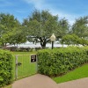 a gated walkway with bushes and trees on either side of it
