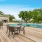 a deck with tables and chairs on it with trees in the back