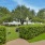 a gated walkway with bushes and trees on either side of it